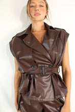 Load image into Gallery viewer, Close-up of a model wearing the Chocolate Luxe faux leather set, highlighting the structured sleeveless jacket, oversized lapels, adjustable buckle belt, and matching chocolate-brown shorts.