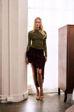Load image into Gallery viewer, Burgundy asymmetric high-low ruffle skirt with sculptural cascading details styled with a fitted olive green ruched long-sleeve top.