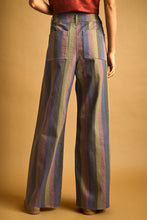 Load image into Gallery viewer, Model wearing Retro Revival Striped Wide-Leg Jeans with multicolor vertical stripes, a high-rise waist, dramatic wide-leg silhouette, and raw-edge hems.