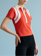 Load image into Gallery viewer, Red short-sleeve polo top with white contrast collar and panel detailing, styled with black shorts for a sporty chic look.