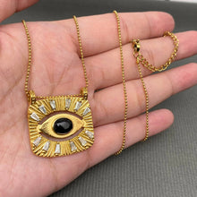 Load image into Gallery viewer, 18K gold-plated All Seeing Eye pendant necklace featuring a black center stone, clear zircon accents and textured sunburst design.