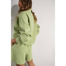Load image into Gallery viewer, Apple green embossed half-zip pullover with relaxed fit and textured fabric styled as a chic lounge top.