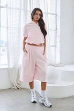 Load image into Gallery viewer, Light pink fleece Bermuda shorts with front pintuck detailing, elastic drawstring waistband, side pockets, relaxed fit, and soft stretch fabric.