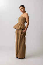 Load image into Gallery viewer, Woman wearing a beige strapless peplum top and wide-leg pants on a white background