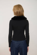 Load image into Gallery viewer, Person wearing a black ribbed sweater with a fur collar and blue jeans on a plain background