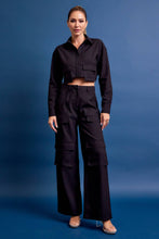 Load image into Gallery viewer, Structured black cargo pants with stretch, wide leg silhouette, and utility pockets. Elevated everyday style. Matching jacket sold separately.