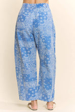 Load image into Gallery viewer, Blue paisley patterned pants on a beige background