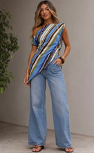 Load image into Gallery viewer, Blue and green striped one-shoulder draped top with asymmetrical design, worn by a model.