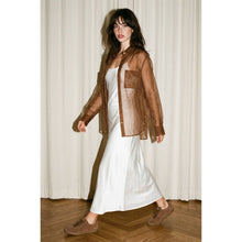 Load image into Gallery viewer, Woman wearing a sheer chocolate brown oversized organza button-down shirt layered over a camisole with leather skirt for a modern chic look.