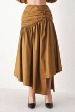 Load image into Gallery viewer, Caramel brown cotton midi skirt with a shirred waist, gathered full silhouette and dramatic asymmetrical draped hem.