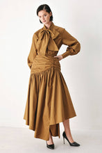 Load image into Gallery viewer, Caramel brown cotton midi skirt with a shirred waist, gathered full silhouette and dramatic asymmetrical draped hem.