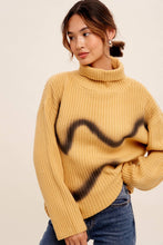 Load image into Gallery viewer, Woman wearing a mustard yellow sweater with black abstract design on a beige background