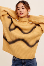 Load image into Gallery viewer, Woman wearing a mustard yellow sweater with black wavy patterns on a beige background