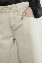 Load image into Gallery viewer, Beige denim pants with a close-up of a button and stitching detail.