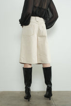 Load image into Gallery viewer, Person wearing a beige denim bermuda shorts and black boots against a white background