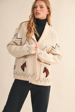 Load image into Gallery viewer, Woman wearing a cream-colored sweater with horse designs on a beige background