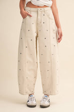 Load image into Gallery viewer, Model wearing cream barrel-leg jeans embellished with silver stud details throughout, featuring a high-rise waist and relaxed statement silhouette.