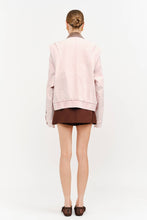 Load image into Gallery viewer, Model wearing an oversized dusty rose denim jacket with contrasting brown corduroy collar, front zipper and relaxed silhouette.
