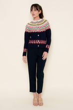 Load image into Gallery viewer, A woman wearing a navy blue Fair Isle cardigan sweater with red, green, yellow, and white patterned detailing across the chest, sleeves, and hem, styled against a neutral background.