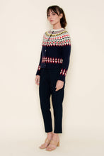 Load image into Gallery viewer, A woman wearing a navy blue Fair Isle cardigan sweater with red, green, yellow, and white patterned detailing across the chest, sleeves, and hem, styled against a neutral background.