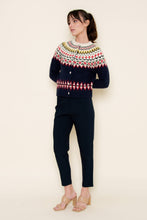 Load image into Gallery viewer, A woman wearing a navy blue Fair Isle cardigan sweater with red, green, yellow, and white patterned detailing across the chest, sleeves, and hem, styled against a neutral background.