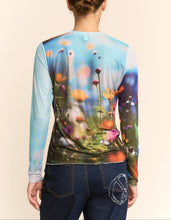 Load image into Gallery viewer, Sheer long sleeve mesh top with vibrant floral field print in soft focus colors, worn by a model.