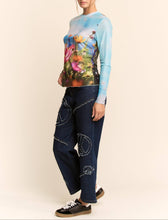 Load image into Gallery viewer, Sheer long sleeve mesh top with vibrant floral field print in soft focus colors, worn by a model.