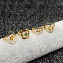 Load image into Gallery viewer, Set of gold rings with various designs on a gray textured background