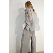 Load image into Gallery viewer, A model showcases a sheer grey organza blouse featuring crisp white contrast sleeves and collar, paired with matching trousers (sold separately), epitomizing modern elegance and style.