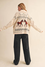 Load image into Gallery viewer, Person wearing a cream-colored sweater with horse design on a beige background