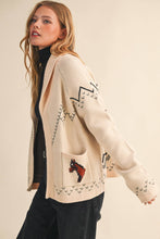 Load image into Gallery viewer, Woman wearing a cream cardigan with patterned design on a beige background