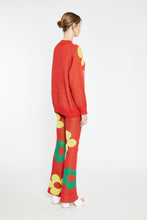 Load image into Gallery viewer, Like its matching sweater, the Red Glitter Floral Knit Pants are attention-grabbing with their metallic sheen and fun print. These cherry red knit pants have a yellow and green floral print, a subtle shimmer and lots of stretch.