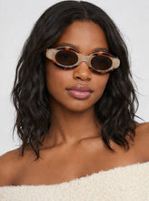 Load image into Gallery viewer, Oval sunglasses with marbled tortoise and cream frame and brown lenses shown on model and product background.