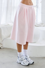 Load image into Gallery viewer, Light pink fleece Bermuda shorts with front pintuck detailing, elastic drawstring waistband, side pockets, relaxed fit, and soft stretch fabric.