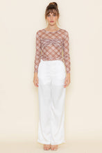 Load image into Gallery viewer, Woman wearing a sheer plaid top and white pants on a beige background