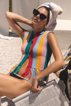 Load image into Gallery viewer, Woman wearing a colorful knitted cover-up and sunglasses, sitting on a chair.