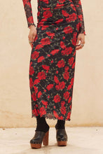 Load image into Gallery viewer, Person wearing a long black dress with red floral pattern on a beige background