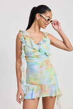 Load image into Gallery viewer, Woman wearing a colorful tie-dye dress with ruffled details on a plain background