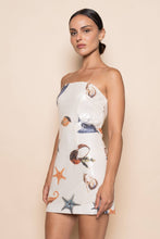 Load image into Gallery viewer, Model wearing a strapless white sequin mini dress featuring ocean-inspired seashell, starfish, and seahorse embellishments in a fitted bodycon silhouette.