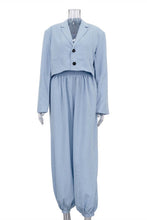 Load image into Gallery viewer, A light blue two-piece outfit displayed on a mannequin, featuring a cropped long-sleeve blazer-style top with two black buttons and matching loose wide-leg pants with gathered cuffs.