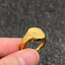 Load image into Gallery viewer, 18K gold-plated stainless steel signet ring engraved with “The World Is Yours” and finished with a high-polish surface.