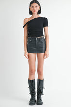 Load image into Gallery viewer, Woman wearing a black one-shoulder top and black leather skirt with black boots on a white background