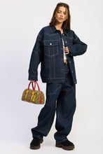 Load image into Gallery viewer, Person wearing a denim outfit holding a colorful bag on a white background