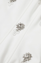 Load image into Gallery viewer, White structured bustier top featuring wide straps and multiple crystal floral embellishments across the front, photographed on a white background.