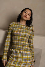 Load image into Gallery viewer, Yellow plaid smocked blouse with ruffle trim and long sleeves worn by model.