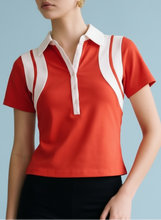 Load image into Gallery viewer, Red short-sleeve polo top with white contrast collar and panel detailing, styled with black shorts for a sporty chic look.