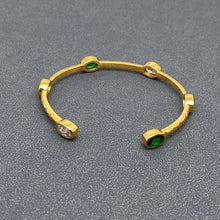 Load image into Gallery viewer, 18K gold-plated open cuff bangle with a hammered textured finish and oval emerald-green and clear zircon stones in gold settings.