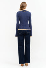 Load image into Gallery viewer, Model wearing The Aspen Double Zip Knit Cardigan in navy with contrast fuzzy trim, double zipper, flared sleeves, and wide-leg dark wash jeans.