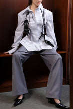 Load image into Gallery viewer, Women's statement pinstripe peplum blouse styled with tailored trousers, featuring exaggerated sleeves and a flared asymmetric-looking hem.