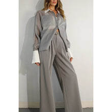 Load image into Gallery viewer, A model showcases a sheer grey organza blouse featuring crisp white contrast sleeves and collar, paired with matching trousers (sold separately), epitomizing modern elegance and style.